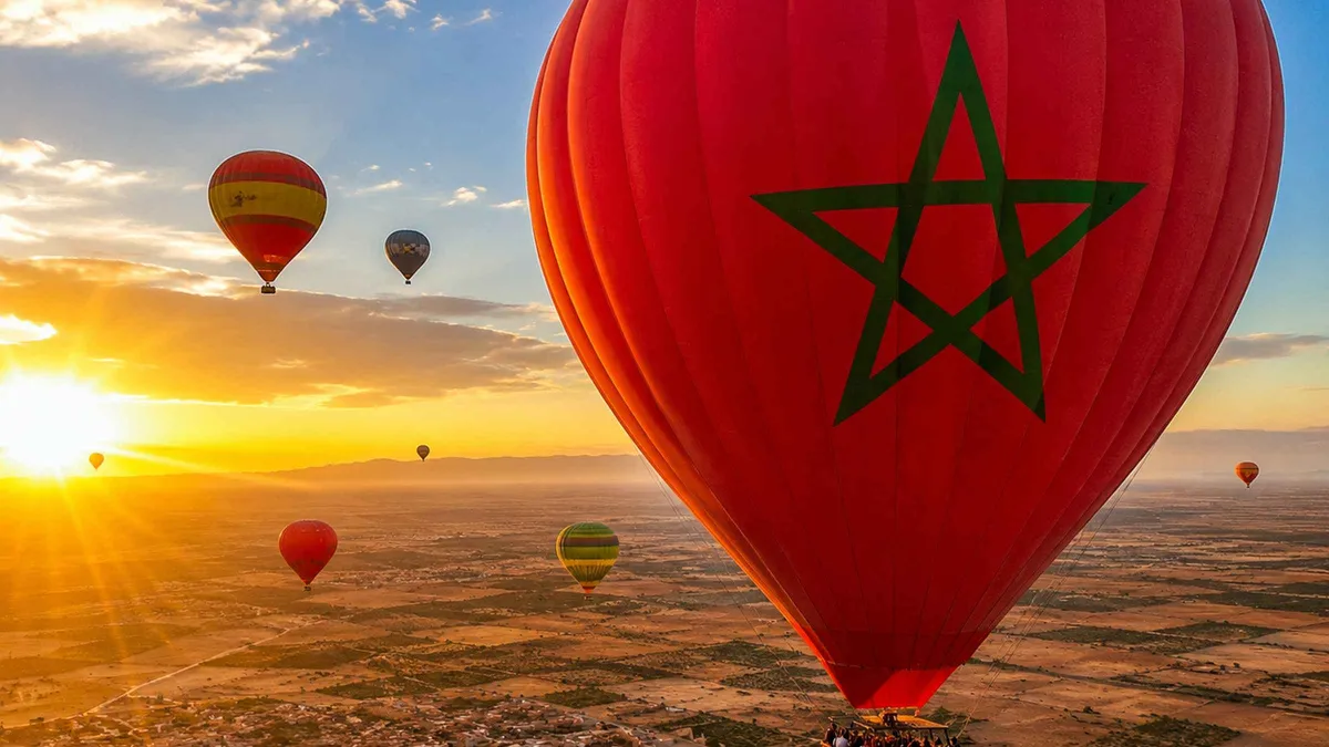 A hot air balloon drifting over the Palmeraie palm groves on a hot air balloon ride in Marrakech, Morocco