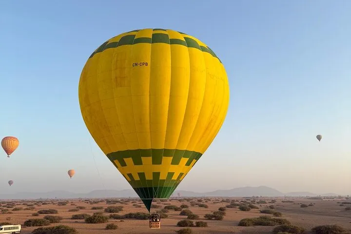 A hot air balloon over clay-roofed Berber houses in the palm groves on a hot air balloon ride in Marrakech, Morocco